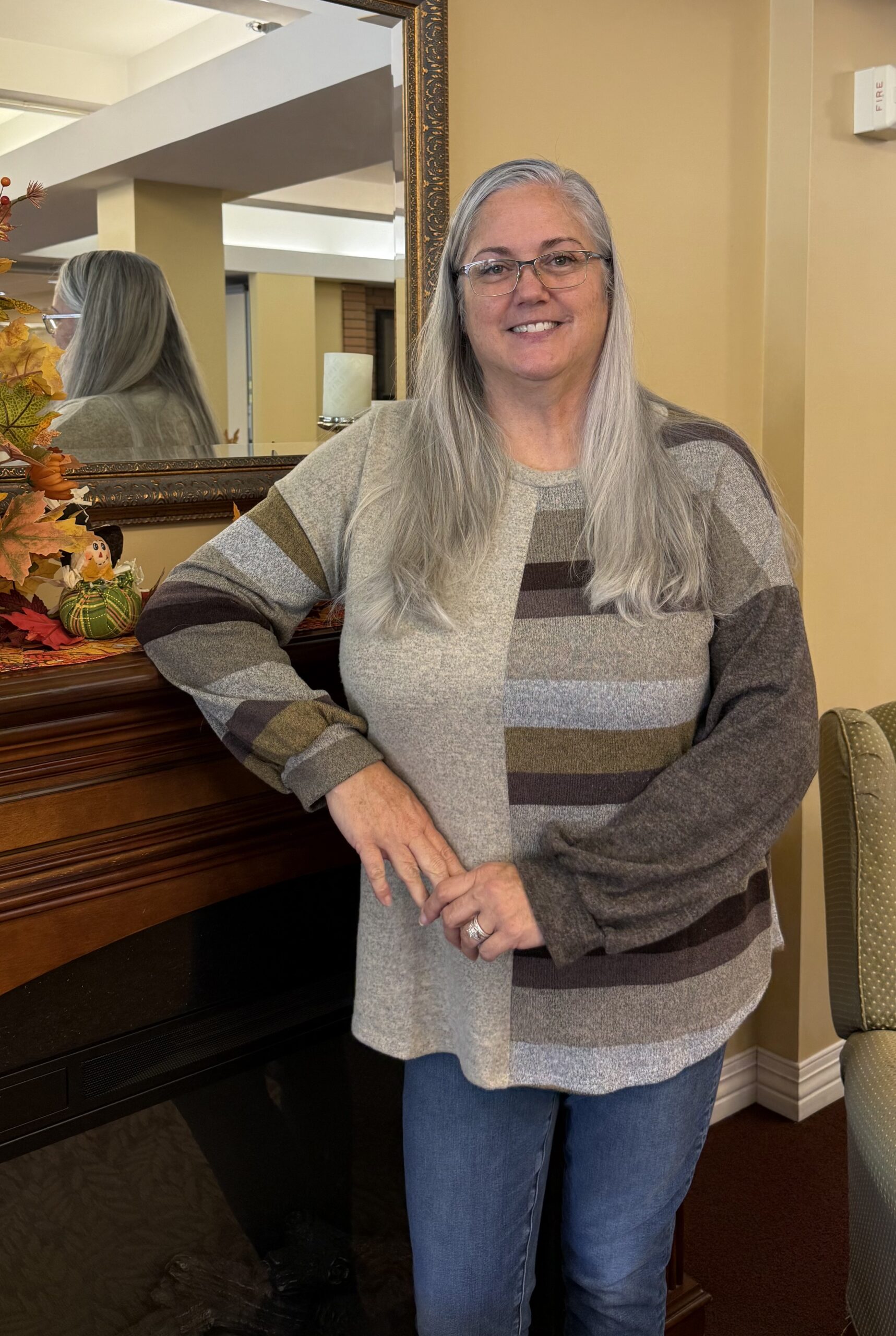 Melissa Kling - women smiles into camera, standing and leaning onto chest