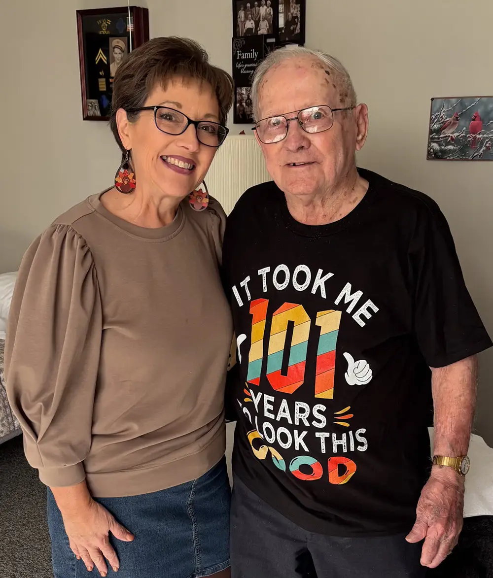 Adult daughter poses with senior father looking into camera