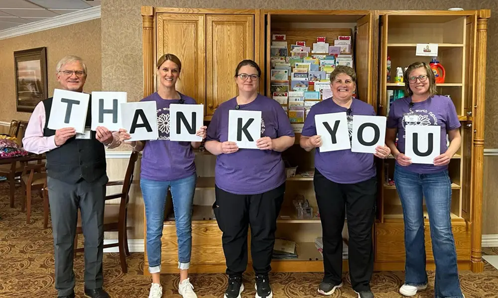employees at SPM hold up letters forming the words Thank You