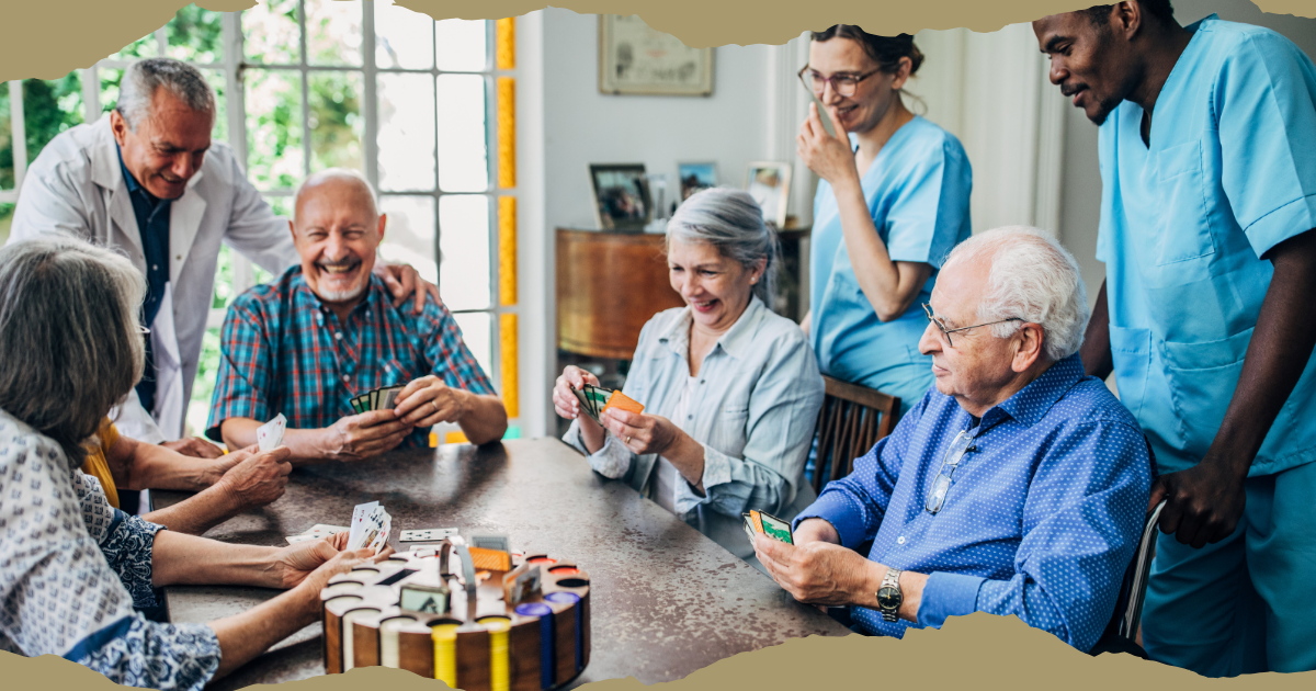 stock photo of nurses around a group of seniors playing cards - laughing and having fun